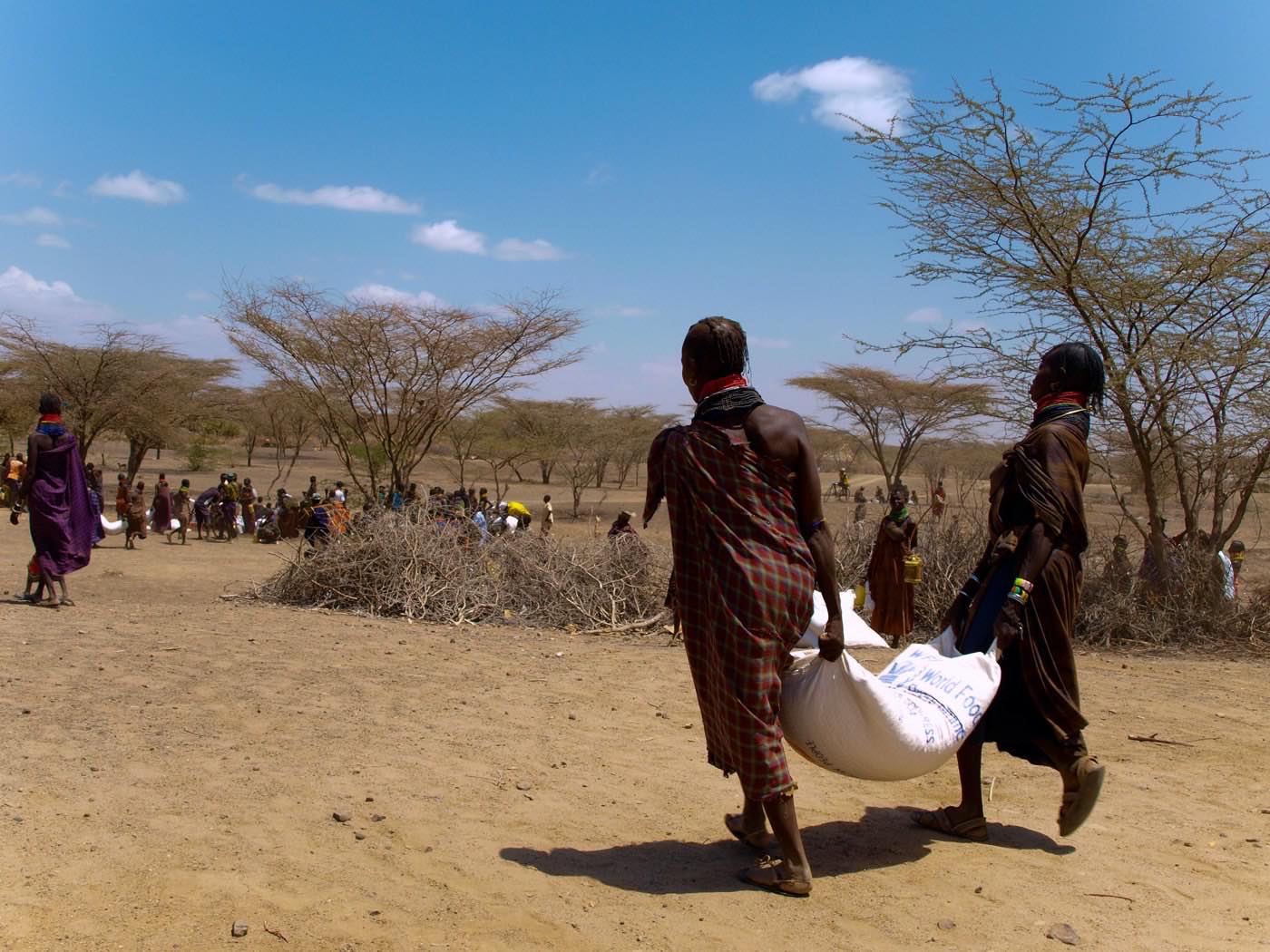 Women carrying a sack of food from a distribution point